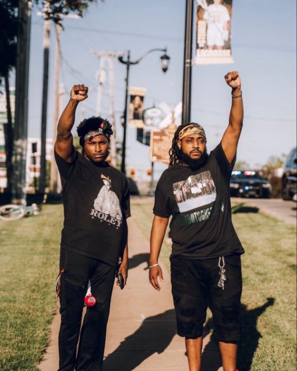 Ebop and a fellow organizer walking with fists raised